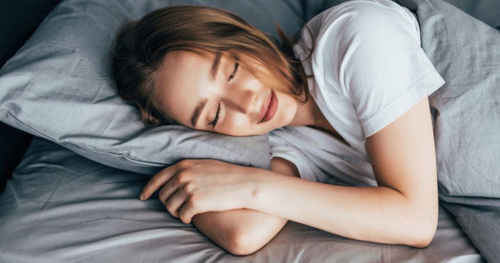 Imagem de uma mulher dormindo feliz, devido ao hormônio que regula o sono.